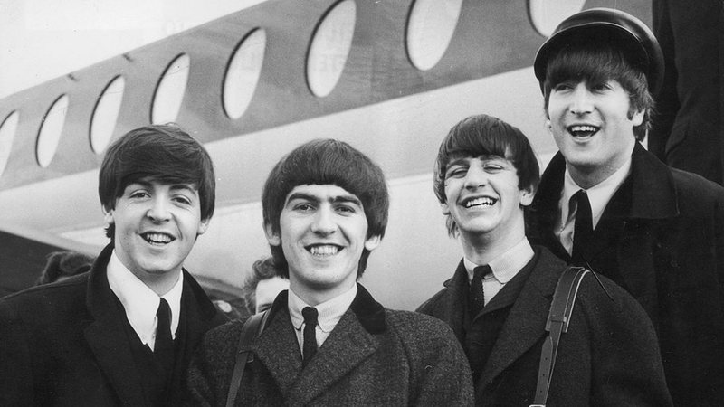 Paul McCartney, George Harrison, Ringo Starr e John Lennon chegam ao aeroporto de Londres em 6 de fevereiro de 1964, após uma viagem a Paris - Getty Images
